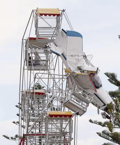 An ultralight plane hangs from a Ferris wheel at a country festival in Australia on Saturday. (Associated Press)
