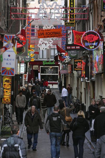 Ads for sex shop, coffee shops and restaurants line Amsterdam’s Red Light district Saturday. The city plans to close up to half of the brothels and marijuana cafes in its city center in a cleanup action.  (Associated Press / The Spokesman-Review)