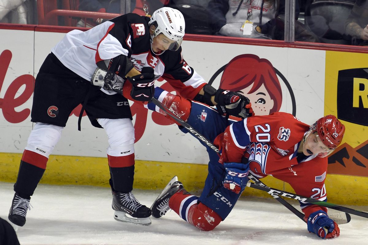 Prince George Cougars forward Austin Crossley (6) and Spokane Chiefs forward Reed Jacobson (20) tangle up during the second period of a WHL hockey game, Fri., Oct. 11, 2019, in the Spokane Arena. (Colin Mulvany / The Spokesman-Review)