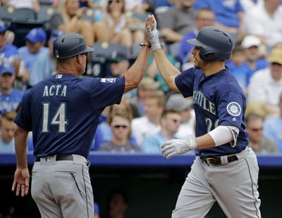 Seattle Mariners' Danny Valencia, left, celebrates with third base coach Manny Acta (14) after hitting a two-run home run during the first inning of the first baseball game in a doubleheader against the Kansas City Royals, Sunday, Aug. 6, 2017, in Kansas City, Mo. (Charlie Riedel / Associated Press)
