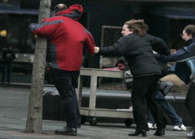 
Pedestrians hold one another against strong wind Wednesday at Copley Square in Boston.
 (Associated Press / The Spokesman-Review)