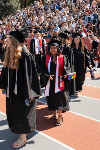 Urvashi Lalwani waits her turn to accept her diploma at this year’s commencement and hand the Whitworth University president a Pride flag in protest of the university’s hiring policy that doesn’t offer LGBTQ+ faculty and staff protections.  (Courtesy of Urvashi Lalwani)
