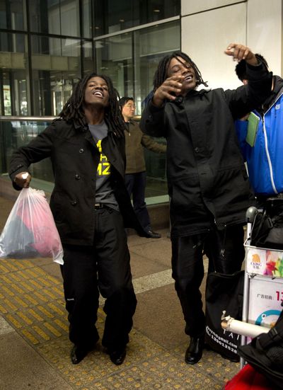 U.S. rappers Pacman, left, and Peso perform a dance at the Beijing Capital Airport after coming back from Pyongyang, North Korea, on Saturday. (Associated Press)