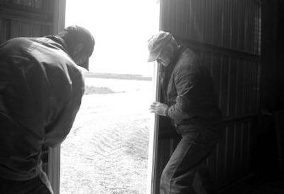 
Wayne Meyer, right, and his son-in-law, Lance Deacon, push the doors shut on their equipment shed after putting away vehicles and equipment.  
 (Photos by JESSE TINSLEY / The Spokesman-Review)