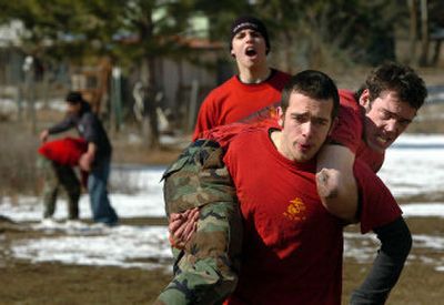 
Marine Corps enlistee Jeff Frisbie, of Coeur d'Alene, carries fellow enlistee Richard Parker, of Potlatch, Idaho, during the obstacle course Saturday. Cheering behind is Mason Brown, another Coeur d'Alene enlistee. 
 (The Spokesman-Review)