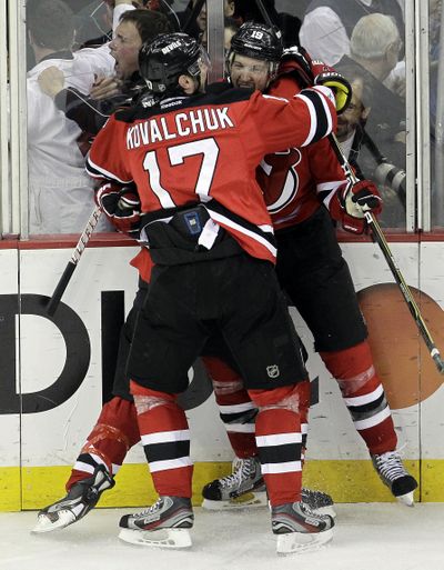 Travis Zajac, right, celebrates with New Jersey teammates after winning overtime goal against Florida. (Associated Press)