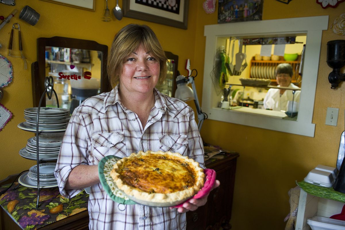 Julie Becker who co-owns Sweetie Pie Cafe with her mother Marilyn Blair, in background, holds a freshly prepared bacon mushroom zucchini quiche. (Colin Mulvany)