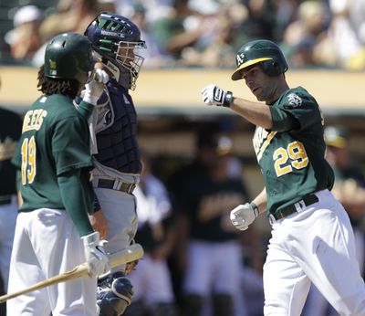 Oakland’s Scott Sizemore, right, celebrates with teammate Jemile Weeks, left, after hitting a fifth-inning homer. (Associated Press)