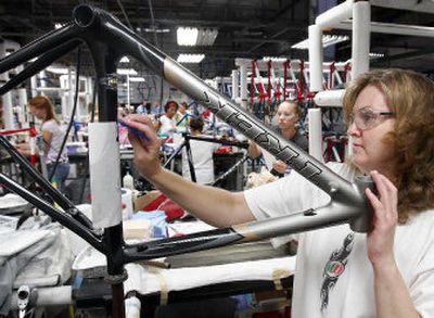 
Justine Winter applies a decal to a bicycle frame at specialty bicycle maker Trek Bicycle Corp. last week in Waterloo, Wis. 
 (Associated Press photos / The Spokesman-Review)