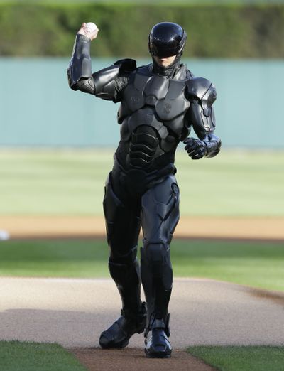 The movie character RoboCop throws out a ceremonial first pitch before a baseball game in Detroit. (Associated Press)