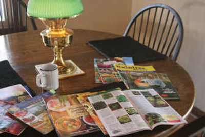 
For many gardeners, this is where it all begins: sitting around the table on a winter night surrounded by stacks of catalogs.
 (Associated Press / The Spokesman-Review)