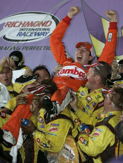 Birthday winner Kyle Busch jumps into the arms of his pit crew.  (Associated Press / The Spokesman-Review)