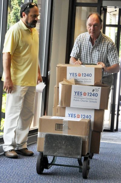 Angelo Paparella, left, and John Michael, supporters of the charter school Initiative 1240, unload boxes of petitions Friday morning. (Jim Camden)