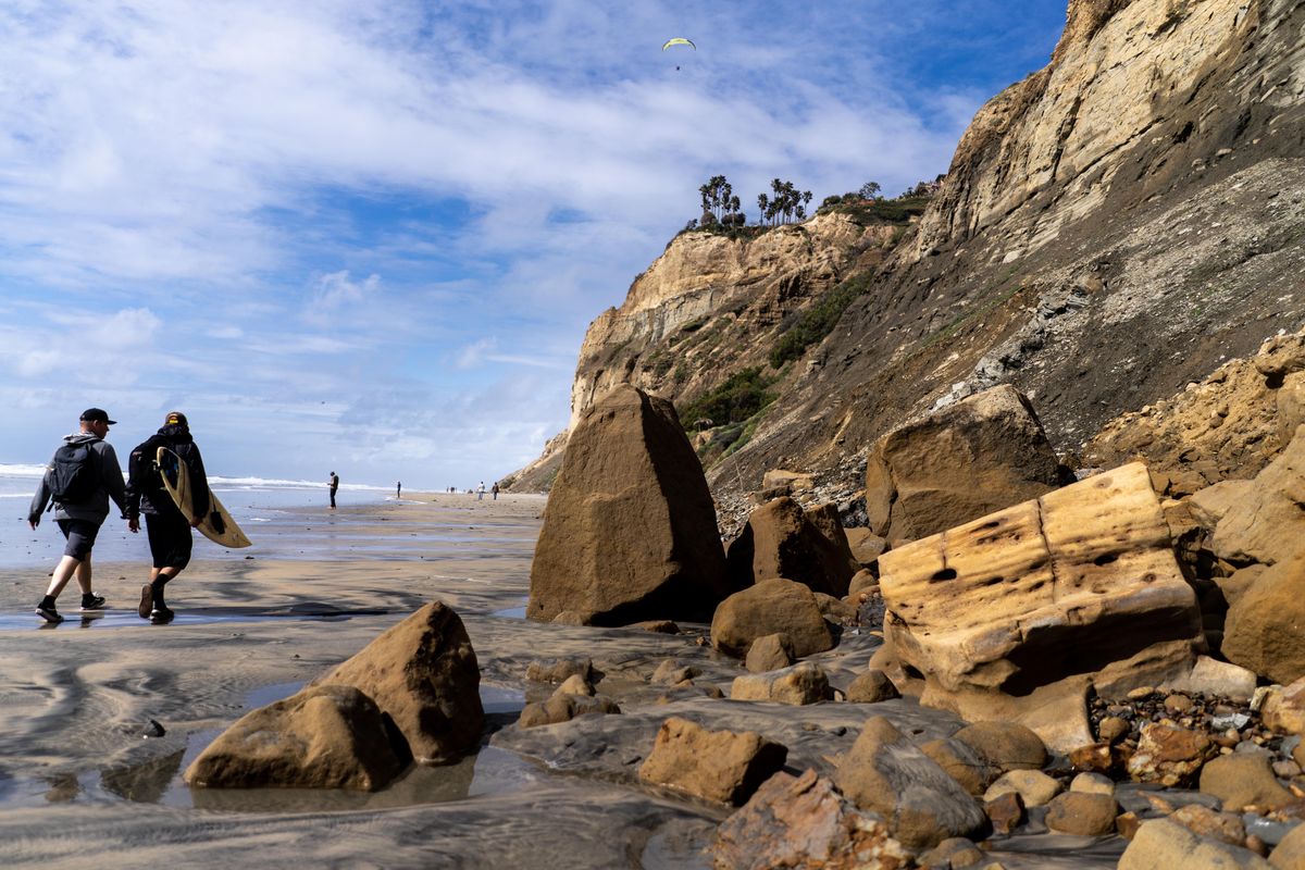 People walk by a major bluff collapse on Black’s Beach in San Diego in late March. (Melina Mara/The Washington Post)