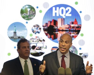 In this Monday, Oct. 16, 2017 photo, New Jersey Sen. Cory Booker, right, speaks while New Jersey Gov. Chris Christie stands behind him during an announcement in Newark, N.J. The New Jersey lawmakers announced they are submitting a bid to Amazon that Newark would be the best location for the company's planned second headquarters. (Seth Wenig / Associated Press)