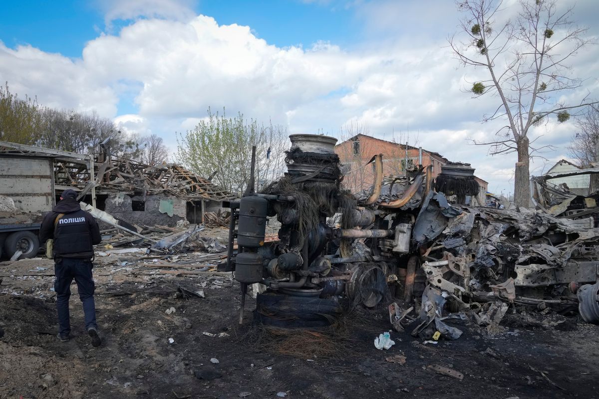 A police officer views a destroyed area Friday following a Russian missile attack on Thursday in Fastov, south of Kyiv, Ukraine.  (Efrem Lukatsky)