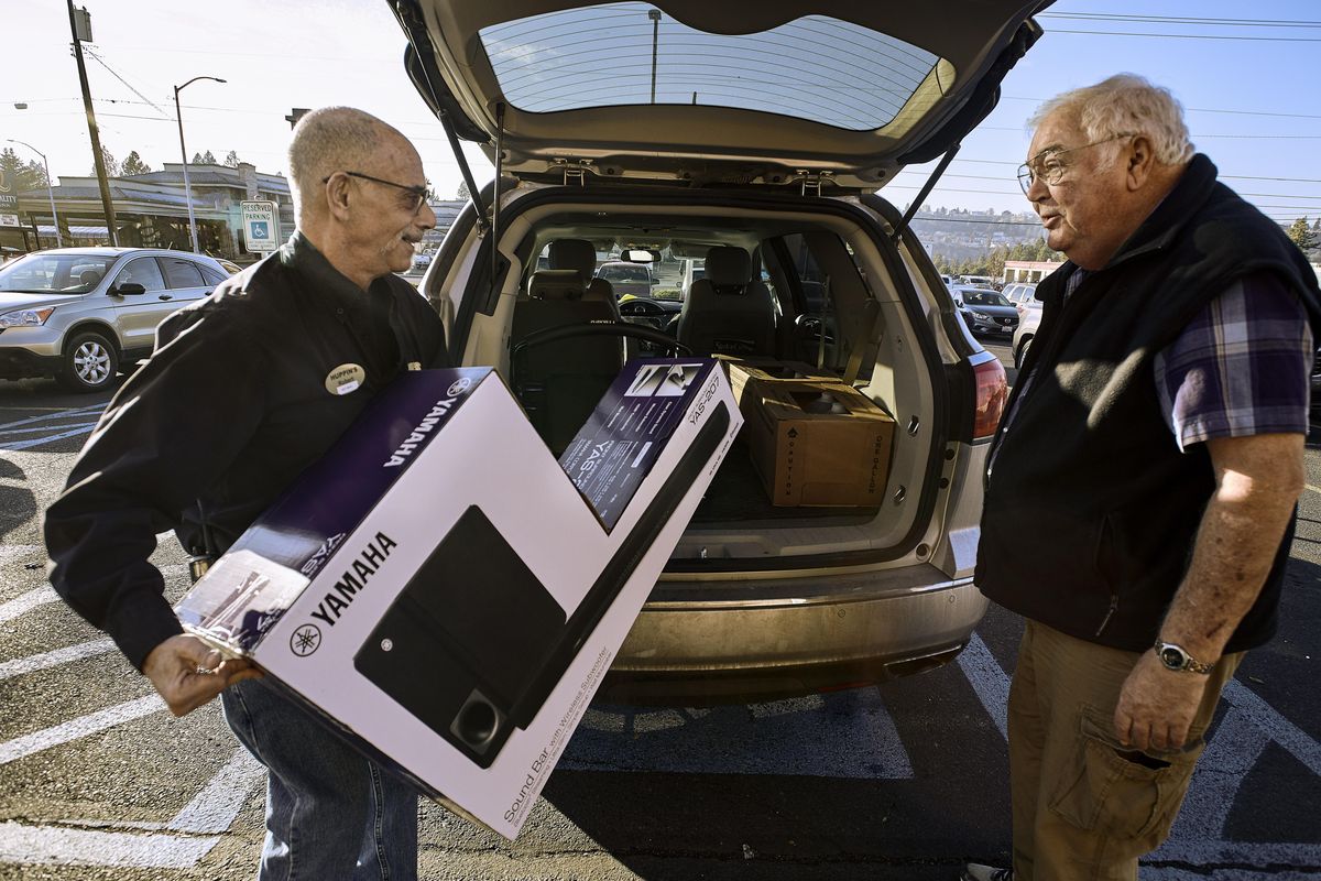 Huppin’s sales associate Robert Specter loads a sound bar for a big-screen television into customer Steve Wahl’s car, Tuesday, Nov. 20, 2018. (Colin Mulvany / The Spokesman-Review)