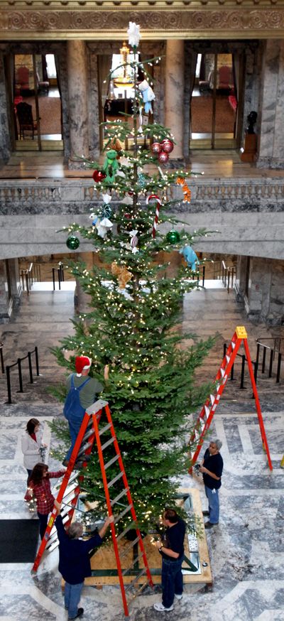 ’Tis the season: Staff from the Department of Enterprise Services decorate this year’s state Christmas tree, a 25-foot-tall noble fir on Monday. The tree will be lit in a ceremony Friday in the Capitol rotunda in Olympia. (Associated Press)