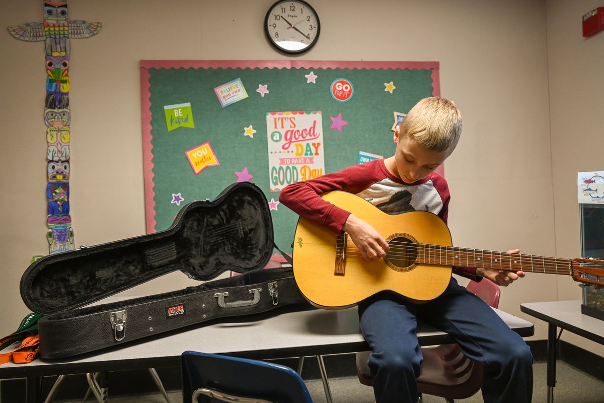 Pomeroy Elementary sixth-grader Robbie Wolf strums his guitar during a break in school on Dec. 19. He takes private lessons from the retired band teacher, but there is no band or choir program for him to participate in at school, because the district has had difficulty finding a new teacher.  (Jesse Tinsley/The Spokesman-Review)