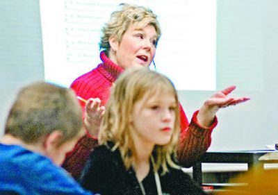 
Audubon Elementary School librarian Lynda Hayashi works with students Tuesday.  Knowing that budget cuts for Spokane schools are on the way, many teachers are 