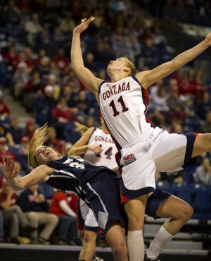 As she shoots for two, Gonzaga's Janelle Bekkering (11) knocks over BYU's Kristen Riley under the basket in the first half Tuesday, Dec. 21, 2010 in the McCarthey Athletic Center. (Colin Mulvany / The Spokesman-Review)