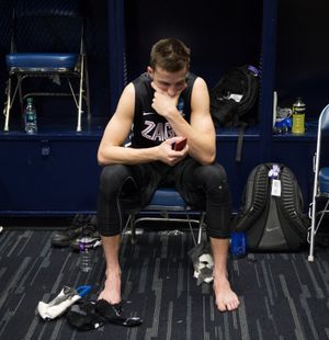 Gonzaga guard Kyle Dranginis studies his phone in the locker room after Sunday’s loss. (Colin Mulvany)