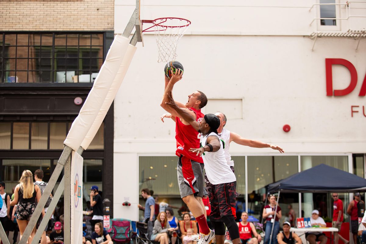 Former Montana State player Kral Ferch soars through the air to the basket against two opponents of the Cali Falcons at Hoopfest on June 30, 2018. Ferches beat the Cali Falcons and advanced to Sunday play, with their next game to be played at 9:30 a.m. Libby Kamrowski/ THE SPOKESMAN-REVIEW (Libby Kamrowski / The Spokesman-Review)