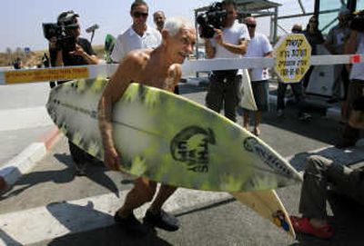 
U.S. surfer Dorian Paskowitz, 86, foreground, from Hawaii carries two surfboards that are part of a personal donation to Palestinian youths in the Gaza Strip, at the Erez Crossing on Tuesday.Associated Press
 (Associated Press / The Spokesman-Review)