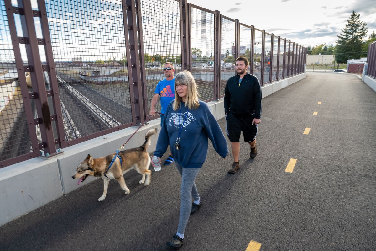 Steve Grono, on left, his wife Raquel Helms and son Chance Grono take the family dog Balto for a walk on the Child of the Sun Trail that follows the North South Corridor highway. Work is underway on the middle stretch of the Children of the Sun Trail, which goes from Hillyard to the river, and WSDOT is trying to decide between two options for its course south of the river to its terminus at I-90.  (COLIN MULVANY/THE SPOKESMAN-REVI)