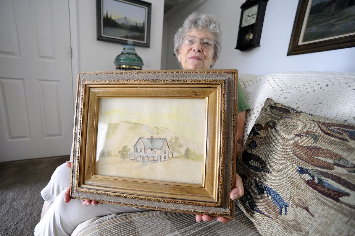 Dorris Cameron holds a painting done by her mother of the home the family built near Thompson Falls after the  1910 fire. Cameron