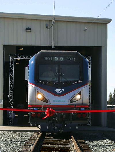 The new Amtrak Cities Sprinter locomotive prepares to break through a red ribbon during unveiling ceremonies at the Siemens Rails Systems factory in Sacramento, Calif., on Monday. (Associated Press)