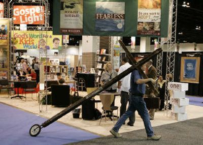 
A worker wheels a cross through the trade show area at the CBA International Christian Retail Show in Denver. Christian retailers walk a tightrope between their religious calling and the need to earn a living. . 
 (Associated Press / The Spokesman-Review)