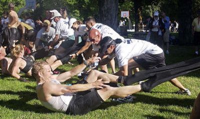 
Volunteers strip wet suits off Ironman competitors after the 2.4-mile swim at City Park in Coeur d'Alene on Sunday morning. 
 (Tom Davenport/ / The Spokesman-Review)