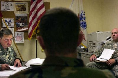 
Captain Jason Johnson, left, holds a meeting in his office at the Hayden Lake Army Reserve office recently. Johnson will be in command of the B Company of the 321st Engineering Battalion in Iraq when they are deployed later this year. 
 (Jed Conklin / The Spokesman-Review)