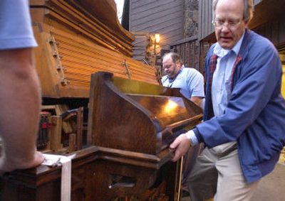 
Doug Pottratz, right, helps Bryan Osso, center, load the organ into a truck outside his Spokane Valley home early Wednesday. 
 (Joe Barrentine / The Spokesman-Review)