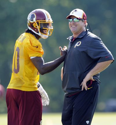 Washington Redskins QB Robert Griffin III, left, is happy to have a head coach like Jay Gruden, who Griffin says believes in him. (Associated Press)