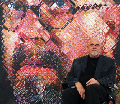 Artist Chuck Close sits in front of one of his paintings, a self Portrait, on May 24, 2007, on show at the exhibition “Chuck Close returned looks, Portraits 1969 / 2006” in the “Ludwig Forum” in Aachen, Germany.  (HENNING KAISER/DDP/AFP)