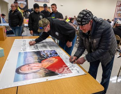 Brett Ferger, right, signs a banner in honor of Ana Vetter, who died in a construction accident at the Spokane Tribe Casino on Tuesday. Her union, Local 59, held a memorial Thursday at its union hall, 127 E. Augusta Ave. “She was a sweetheart,” said Ferger, who was working near Vetter when the accident happened.  (COLIN MULVANY/THE SPOKESMAN-REVIEW)