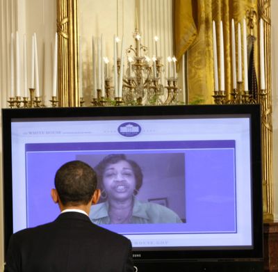 President Barack Obama listens to a video question submitted from the Internet as he holds an “Open For Questions” town hall style meeting in the East Room of the White House on Thursday.  (Associated Press / The Spokesman-Review)