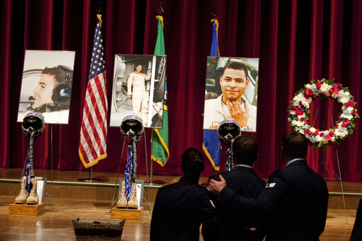 Staff Sgt. Amy Lacy and Senior Airmen Antonio Rapp and Cody Haynes pause after Tuesday’s memorial for Fairchild Air Force Base personnel, from left, Capt. Mark Tyler Voss, Capt. Victoria Pinckney and Tech. Sgt. Herman Mackey III, at the INB Performing Arts Center. (Tyler Tjomsland)