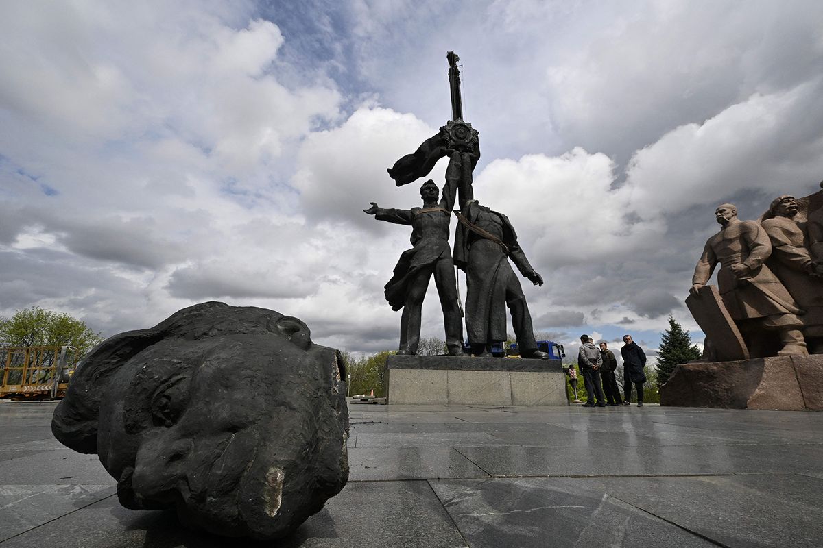 Workers dismantle the Soviet monument to Ukraine-Russia friendship in Kyiv on April 26, 2022, amid Russian invasion of Ukraine. - Authorities in Kyiv on April 26, 2022, began demolishing a monument symbolizing historic ties between ex-Soviet Ukraine and Russia, AFP correspondents reported, more than two months after Moscow
