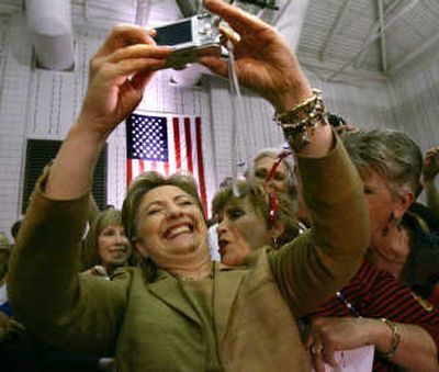 
Democratic presidential hopeful Sen. Hillary Rodham Clinton, D-N.Y., snaps their picture as Helen Matta of New Bern, N.C., kisses her at a rally in Greenville, N.C., Monday.
 (The Spokesman-Review)
