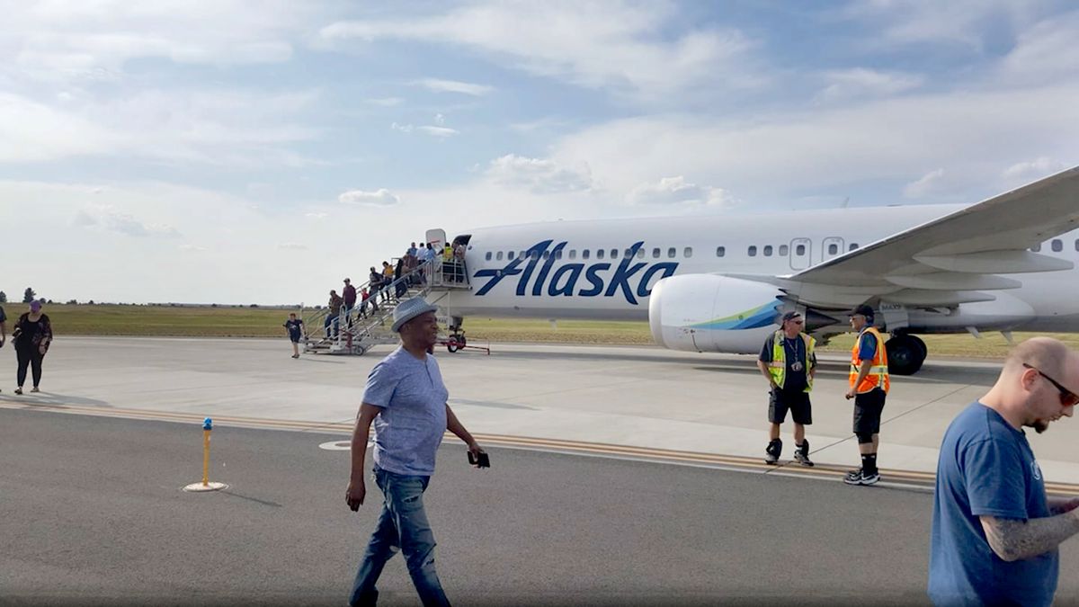 Passengers deplane after a first-class passenger was arrested for handing a flight attendant a note indicating he had a bomb and would detonate it if the plane was not diverted from Seattle, according to federal court documents.  (Courtesy of Scott Mackie)