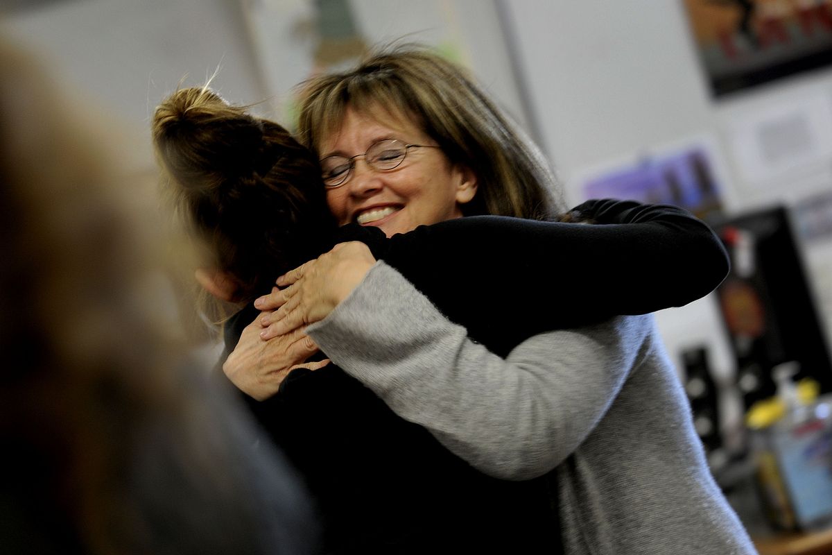 Happiness coach Leslie Villelli hugs a student at Post Falls High School after teaching a class on Thursday. Villelli has been a life coach for more than 30 years, given seminars and published articles. She has twice been named businesswoman of the year in Spokane. (Kathy Plonka)