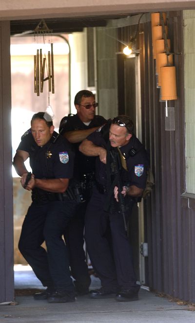 ORG XMIT: IDLEW101 Lewiston,Idaho, police officers make their way through a breezeway of a home west of Albertsons grocery store looking for a robbery suspect Wednesday, June 10, 2009 in Lewiston, Idaho.(AP Photo/Lewiston Tribune, Kyle Mills) (Kyle Mills / The Spokesman-Review)