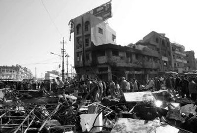 
Iraqis gather Monday at the scene of Sunday's twin car bomb attack that killed more than 60 people in Baghdad. On Monday, a string of car bombings and other attacks  killed more than 40 civilians  in Baghdad and elsewhere in the country.
 (Associated Press / The Spokesman-Review)