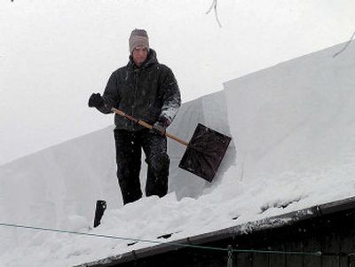 
Randall Converse shovels snow off the roof on his parents' house Friday in Scriba, N.Y.  
 (Associated Press / The Spokesman-Review)
