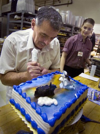 
Kalah Anson, right, watches Rosauers baker Vern Bott work on a birthday cake order at the Browne's Addition store.  Bott used his artistic skills with an airbrush to create the cake scene. 
 (Christopher Anderson / The Spokesman-Review)