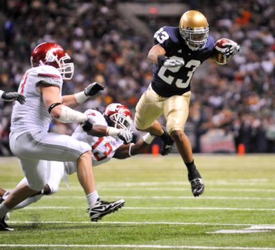 Seahawks draft pick Golden Tate of Notre Dame tries to elude Washington State Cougars  defenders last fall.  (File Associated Press)