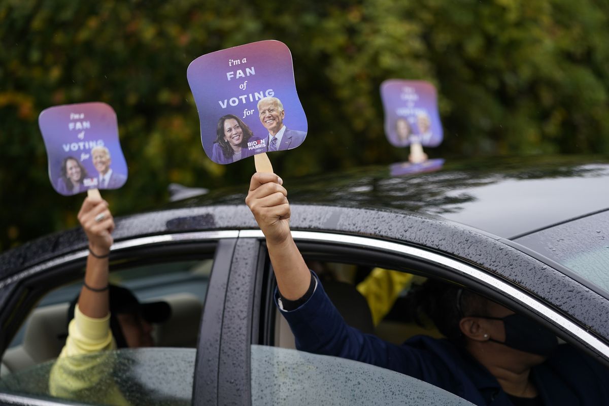 Biden supporters hold up fans during a "Souls to the Polls" drive-in rally for Democratic presidential candidate former Vice President Joe Biden at Sharon Baptist Church, Sunday, Nov. 1, 2020. (Andrew Harnik)